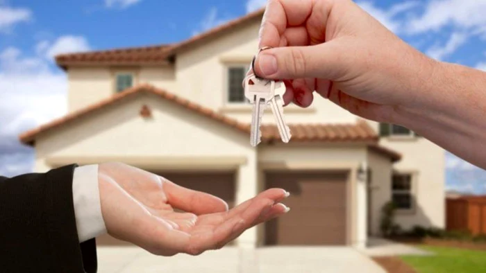 Someone hands over the keys to the new house to the owner