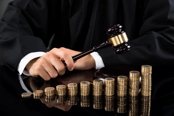 A judge hits the hammer of coin files placed in ascending order