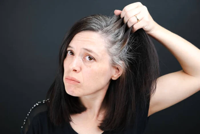 A woman who looks with concern at her hair prematurely premature photos Istock