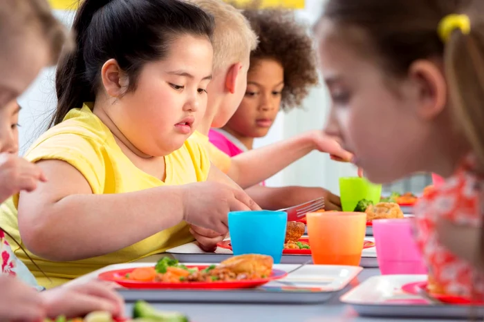 More children, including obese sitting at the table and eating photo source Impact Monash Edu