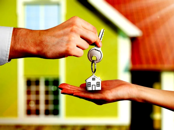 Someone hands over the house key to the tenant