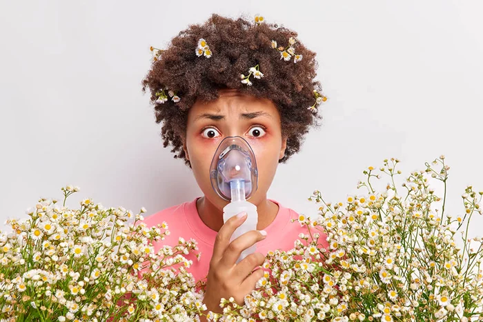 Woman with mask for inhalations, surrounded by chamomile flowers Premier Allergy & Asthma