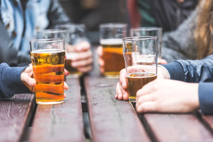 Four men at the table with beer glasses in hand