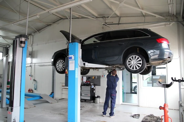 A mechanic repairs a car in service