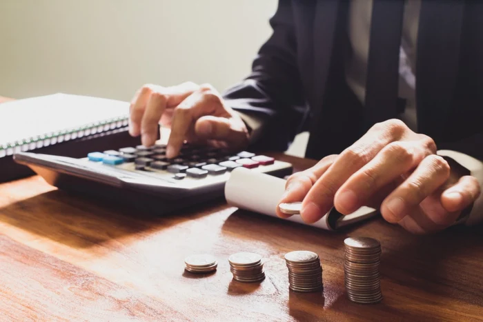 A man calculates by putting coins in files aside
