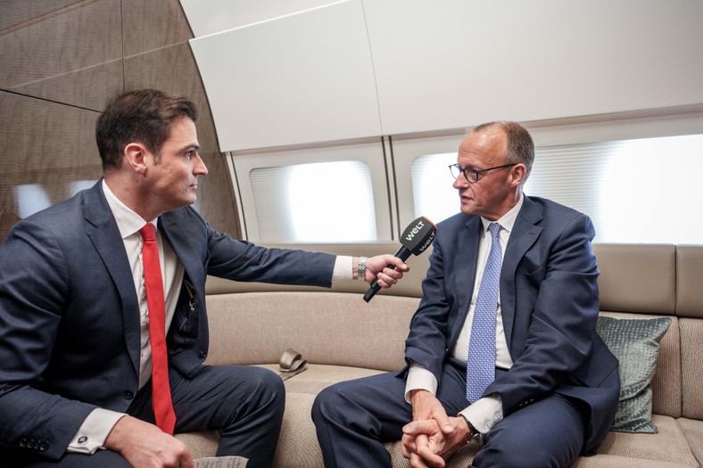 German Chancellor Friedrich Merz (L) during a conversation with the editor -in -chief "Die Welt" Jan Philipp Burgard on a government plane flying to Warsaw, May 7, 2025.
