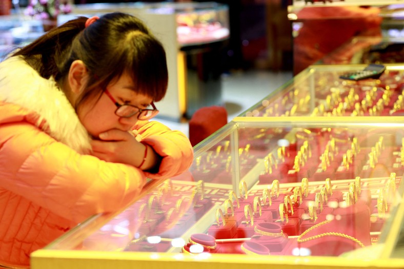 Khinka watching gold bracelets in a jewelry shop in the city of Nantong in the eastern province of China Jiangsu, April 15, 2014.