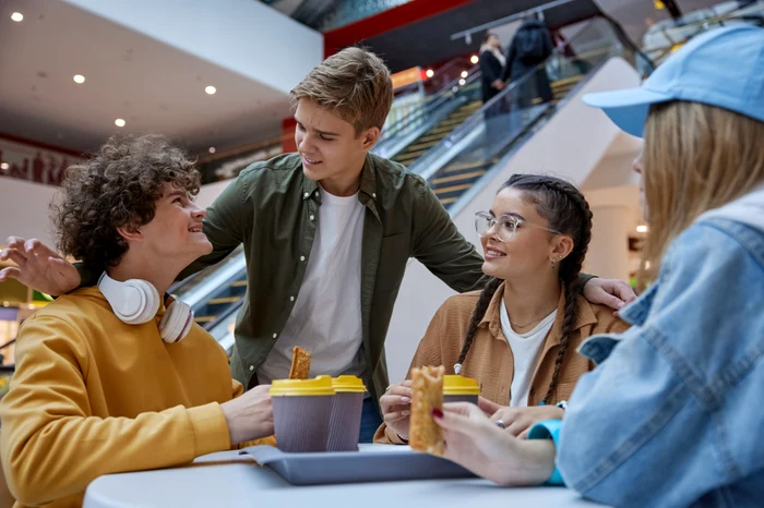 Two boys and two girls at a table in a mall
