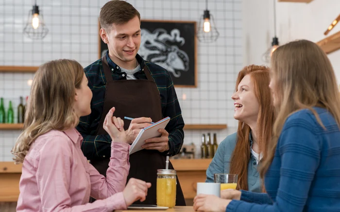 Three young people tell the waiter to bring them
