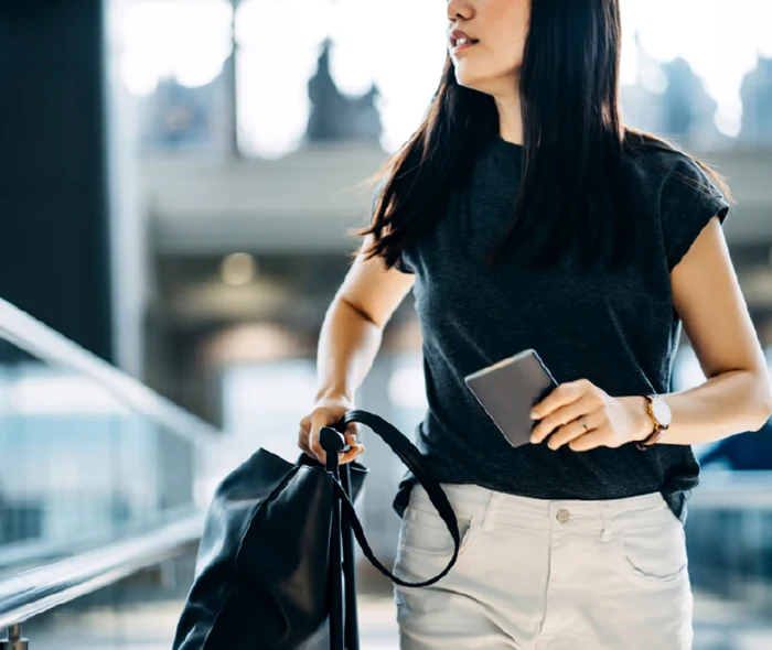 A passenger with handbag and passport, ready to board, at Airport Accor