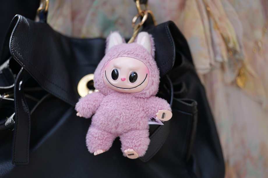Detailed view of the labub toy on a black leather bag YSL during a photo fashion photo session