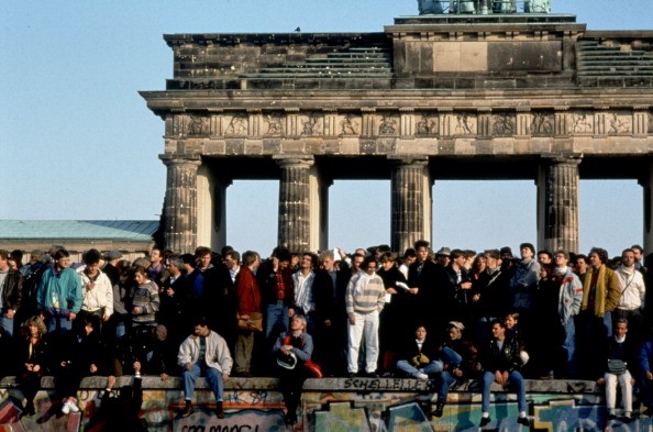 People are standing on the Berlin Wall