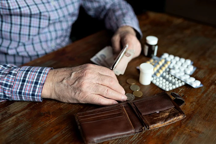 An old man counts the wallet money after buying his medicines