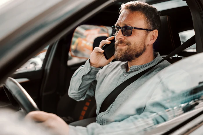 man in the car talks on the phone