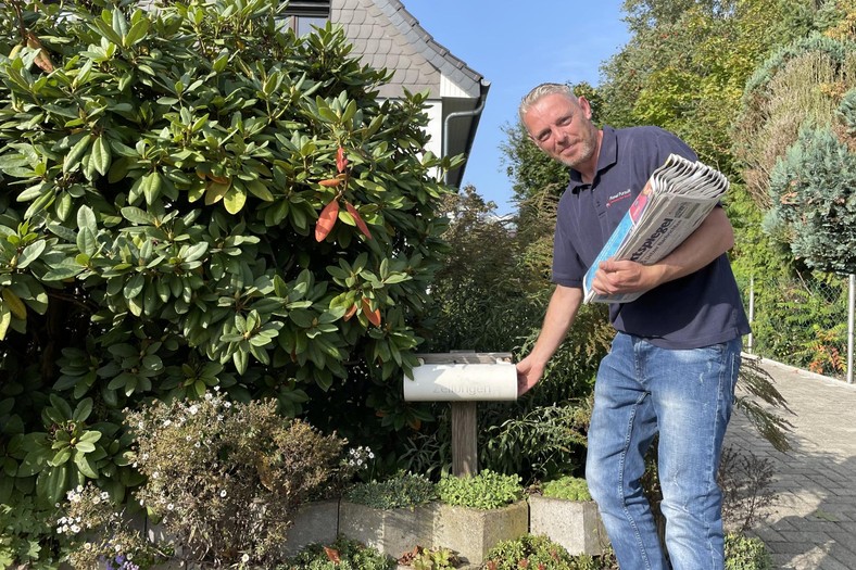 Simon and his wife earns extra money in his free time, spreading newspapers.