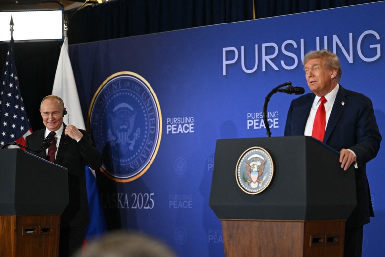 Russian President Vladimir Putin (left) smiles during the speech of the US President Donald Trump at a joint press conference after the USA-Russia summit in the matter of Ukraine, which took place on August 15, 2025 at the Joint Base Elmendorf-Richardson in Anchorage in Alaska.