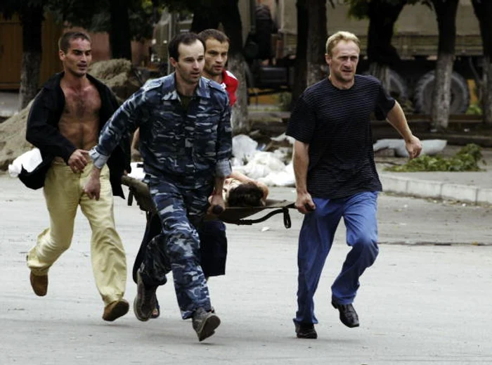 Un elev rănit la școala din Beslan este transportat la spital FOTO: Arhivă