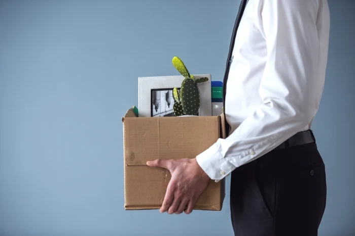 A man carries his things in a box after being fired