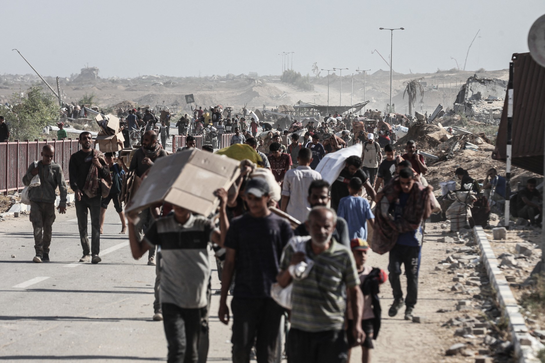 Palestinians struggling with hunger carry packages with humanitarian aid after arriving at the help center in the Netzarim region despite Israeli attacks in the Gaza Strip
