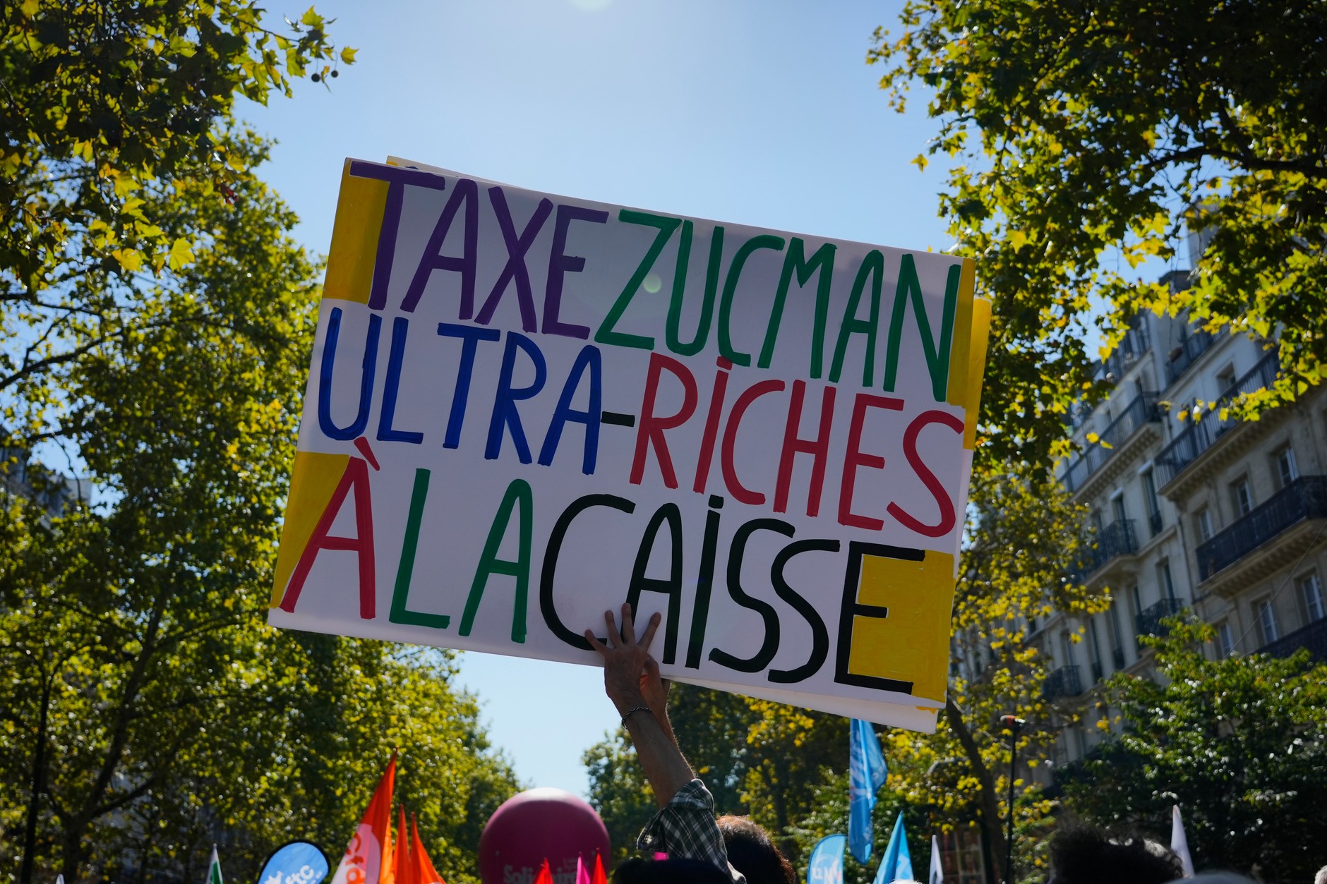 Demonstrators keep a banner supporting the so -called Zmana tax during a rally against savings, Paris, September 18, 2025.