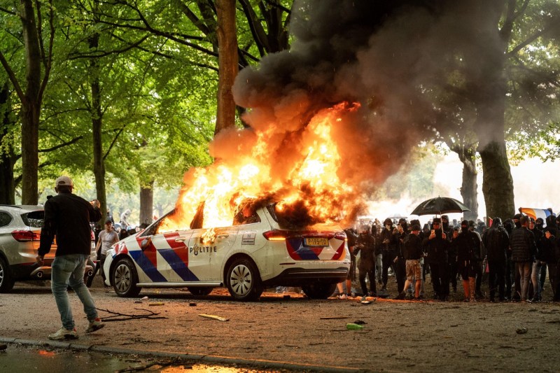 Video Violence to an anti-Imigration protest in The Hague. Police car burned and officer attacked with stones and bottles