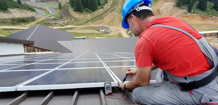 An installer installs photovoltaic panels