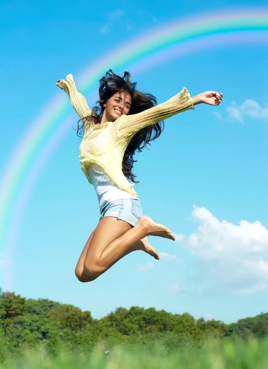 Energy and vitality: young woman doing a happy air jump Shutterstock Photo
