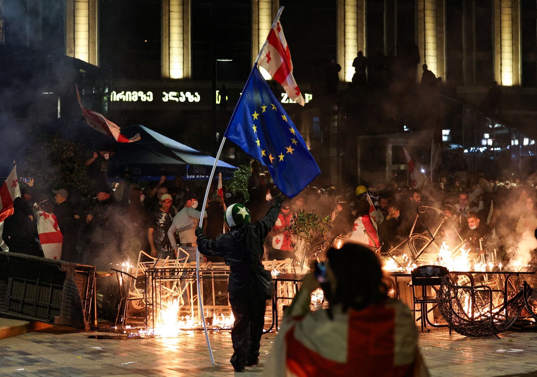 Protesters smoke barricades during clashes with the police during the opposition rally on the day of local elections in the center of Tbilisi, October 4, 2025.