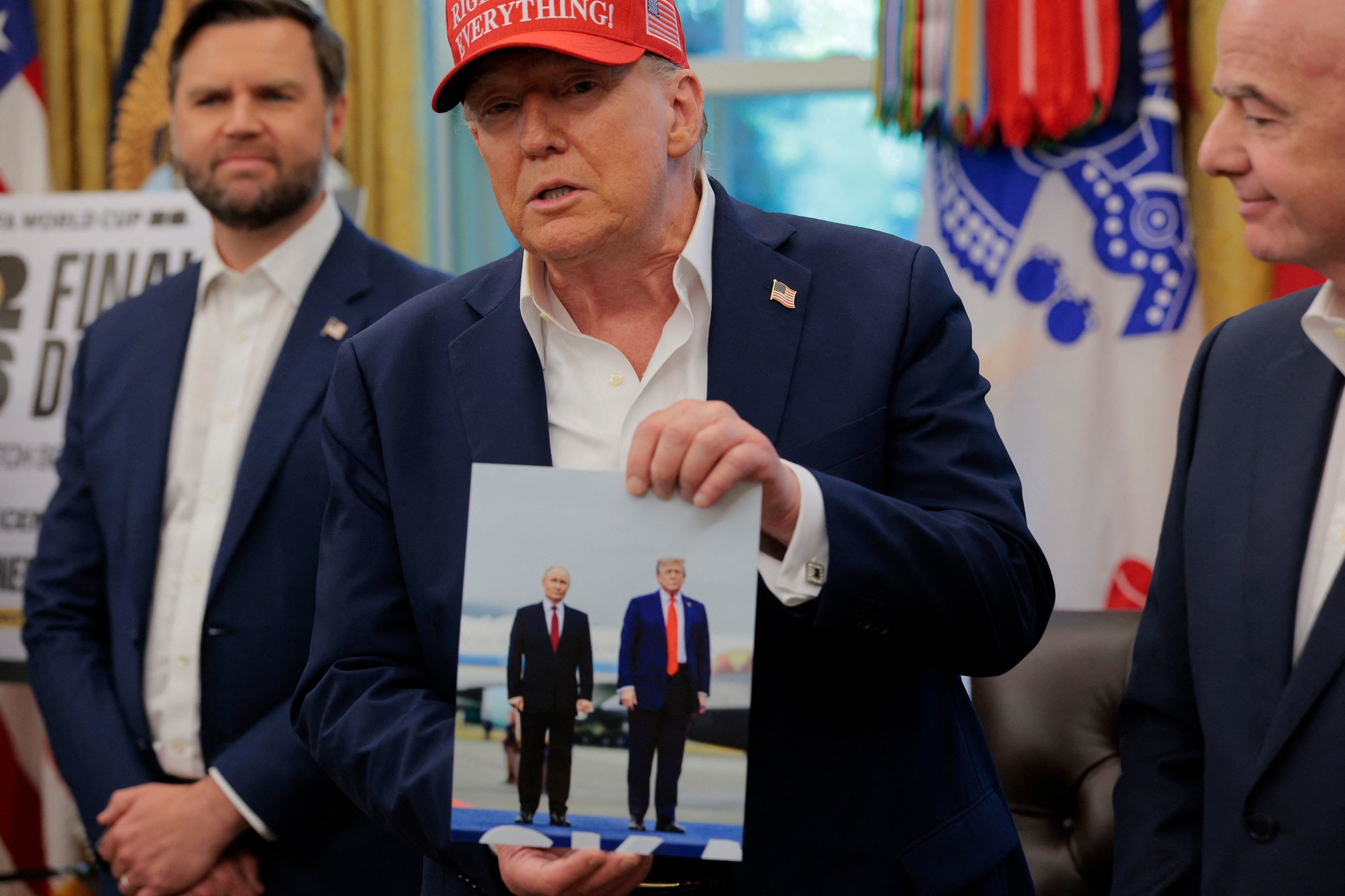 Donald Trump holds a photo from his meeting with Vladimir Putin in Alaska, Washington, August 22, 2025.