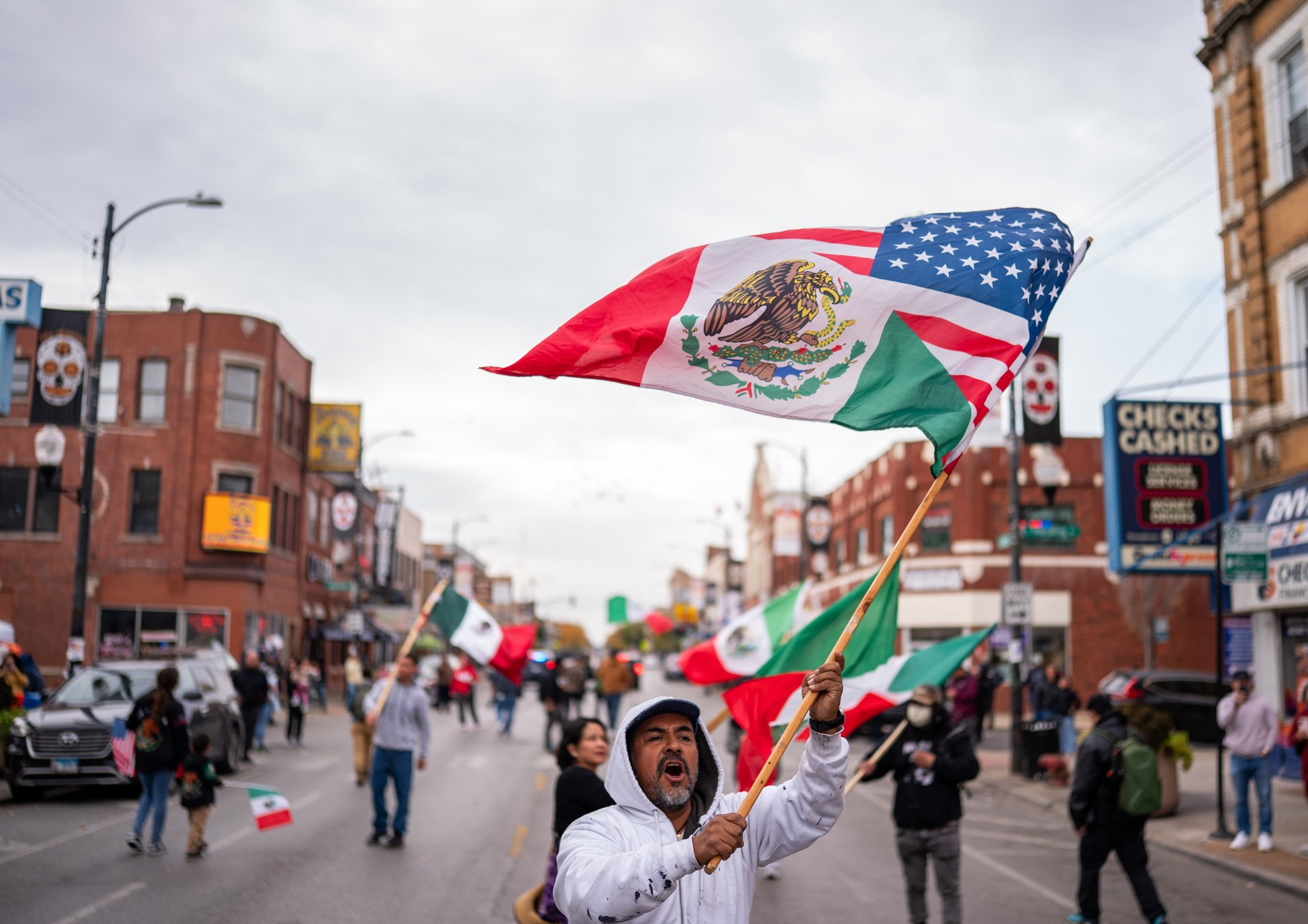 A protester waves a flag with a portion of the Mexican national flag and the United States flag in the Little Village neighborhood during a protest against Immigration and Customs Enforcement (ICE) following two days of raids earlier this week in Chicago, Illinois, U.S., October 25, 2025. Little Village is a neighborhood on Chicago's South Side with a large Mexican-American community