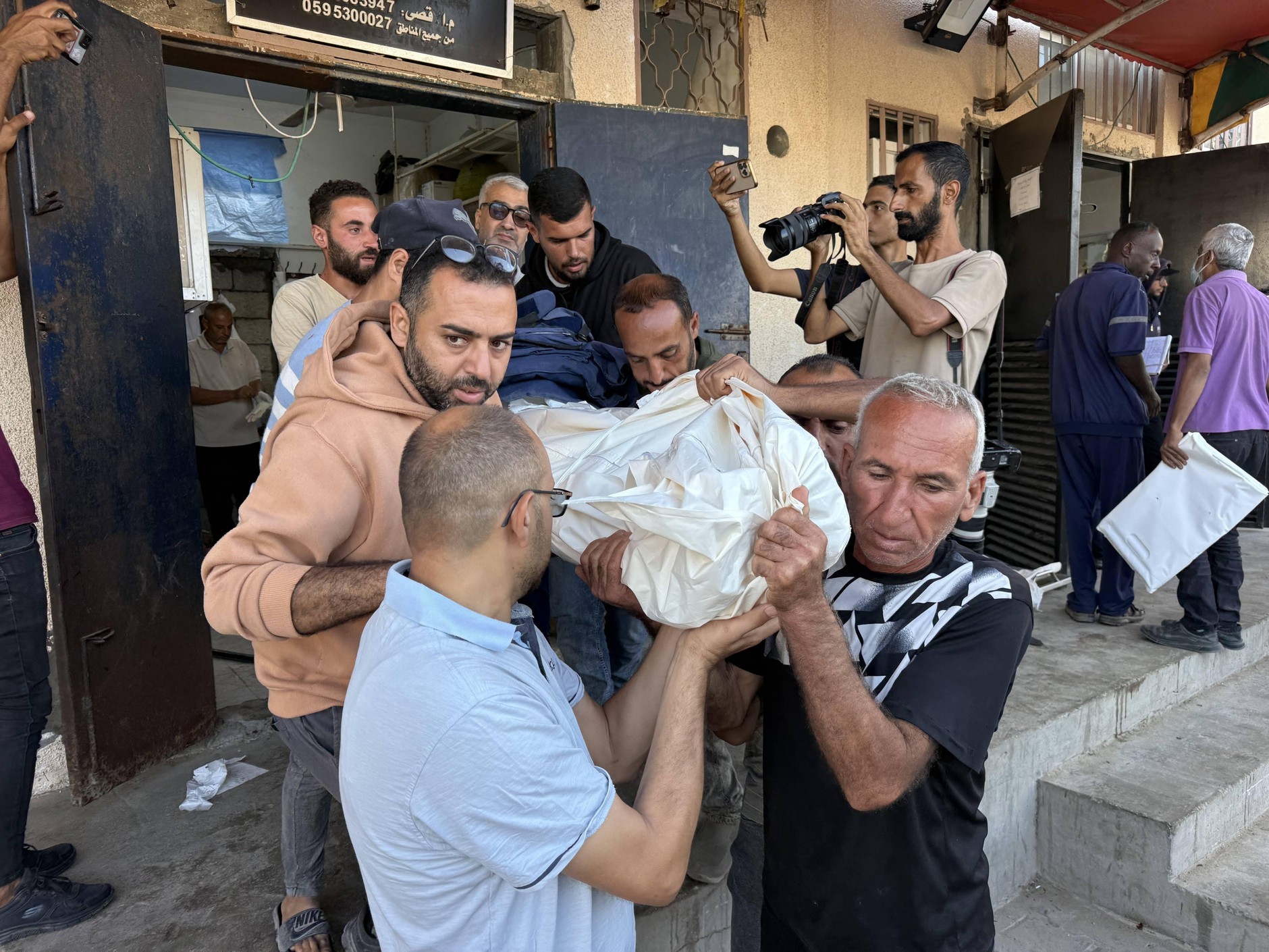 Civilians carrying the body of Palestinian journalist Ahmad Abu Mutayr, who was killed in an Israeli attack in Deir al-Balah despite a ceasefire
