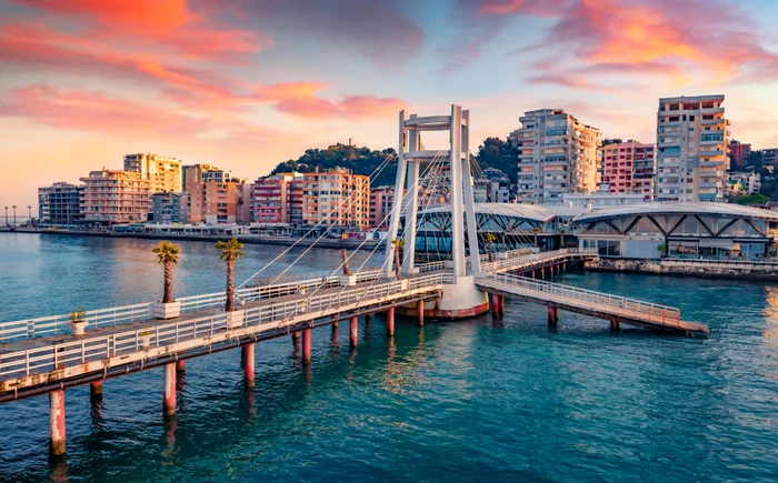 Beautiful Albanian landscape with a bridge going over a water to a block of flats