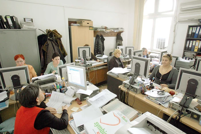 Several employees in an office full of files