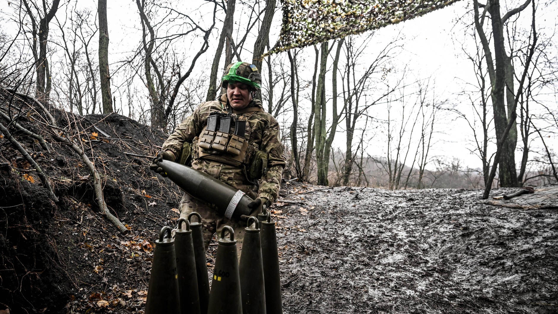 A Ukrainian soldier carries an artillery shell that will be fired at Russian troop positions in the Pokrovsk area, November 20, 2025.