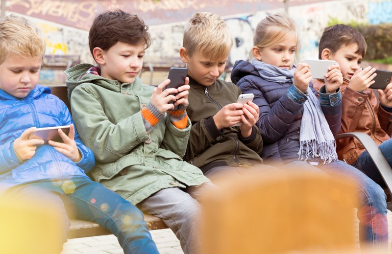 The silence of children in the digital age: each in his own conversation. Today, children no longer get lost in the park. They get lost online. PHOTO: Shutterstock