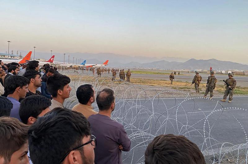 Afghans and American soldiers separated by barbed wire at Kabul airport, Photo: SHAKIB RAHMANI / Profimedia Images