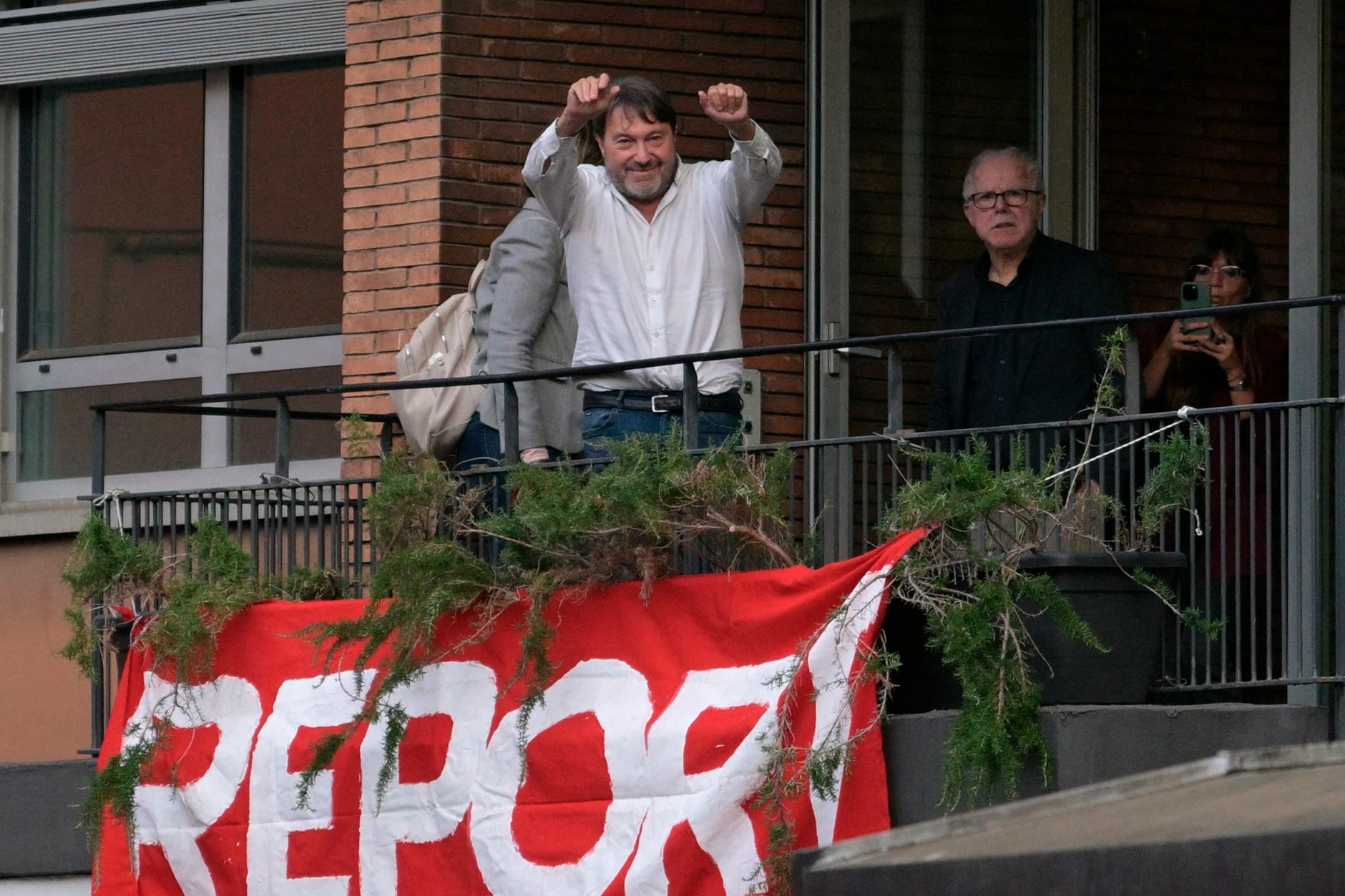 Włoski dziennikarz programu śledczego "Report", Sigfrido Ranucci, macha do swoich zwolenników z balkonu siedziby włoskiego nadawcy telewizyjnego RAI w Rzymie (17 października 2025 r.)