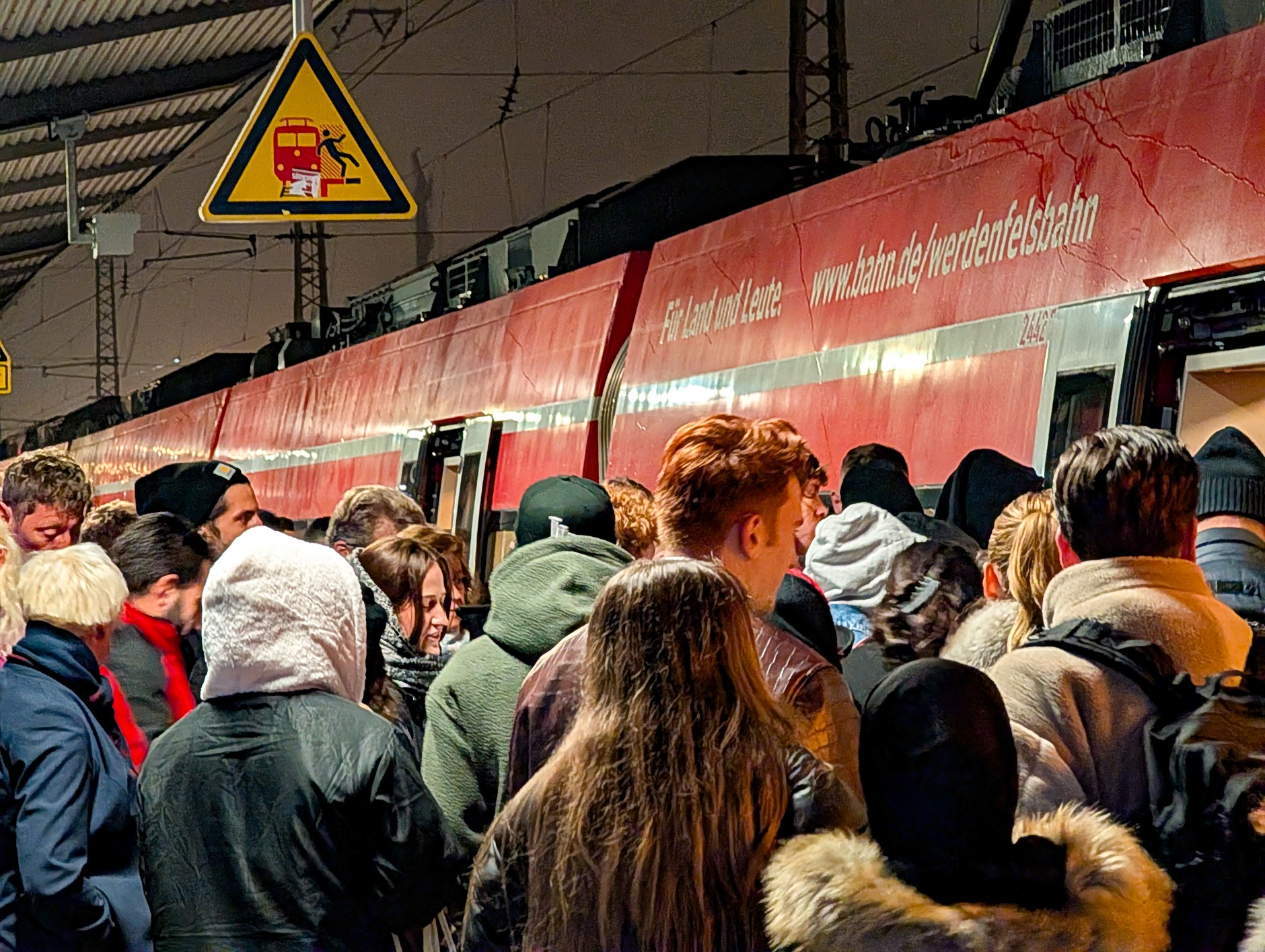 A crowd of passengers crowds to board a DB regional train on the platform of Munich Central Station in Bavaria, Germany, November 6, 2025. 