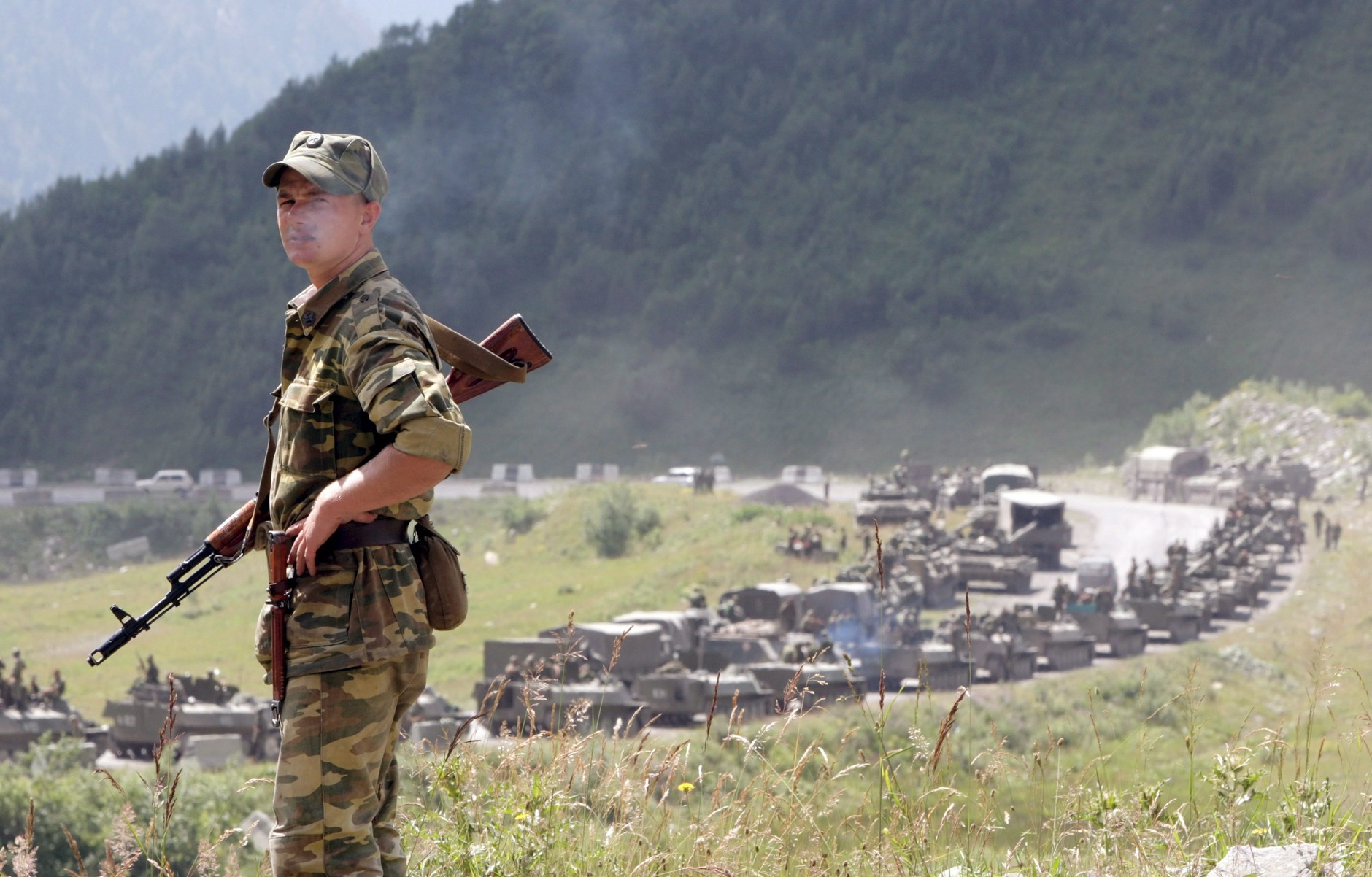 Russian soldier against the background of a column of troops. Tskhinvali, August 9, 2008 