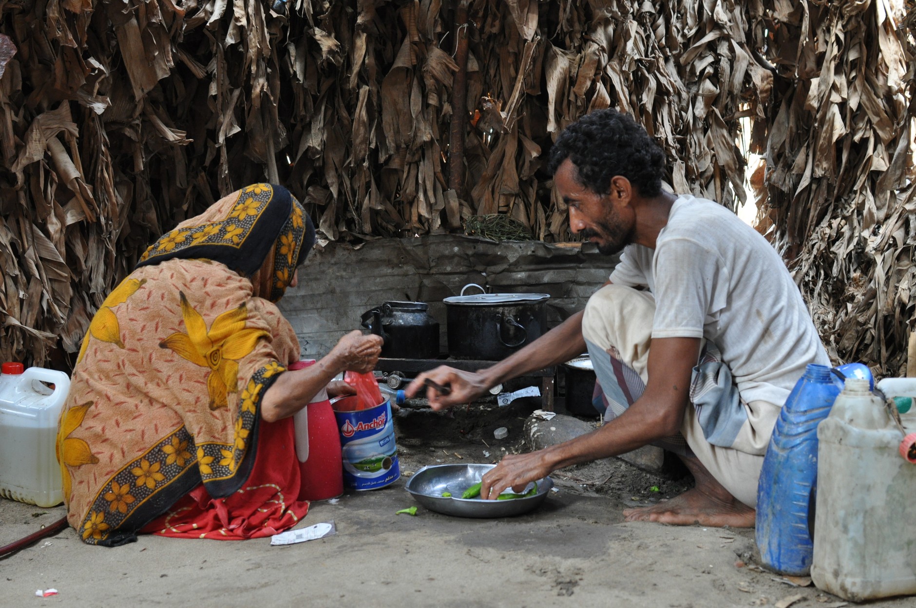 Yemenis preparing food in a makeshift way