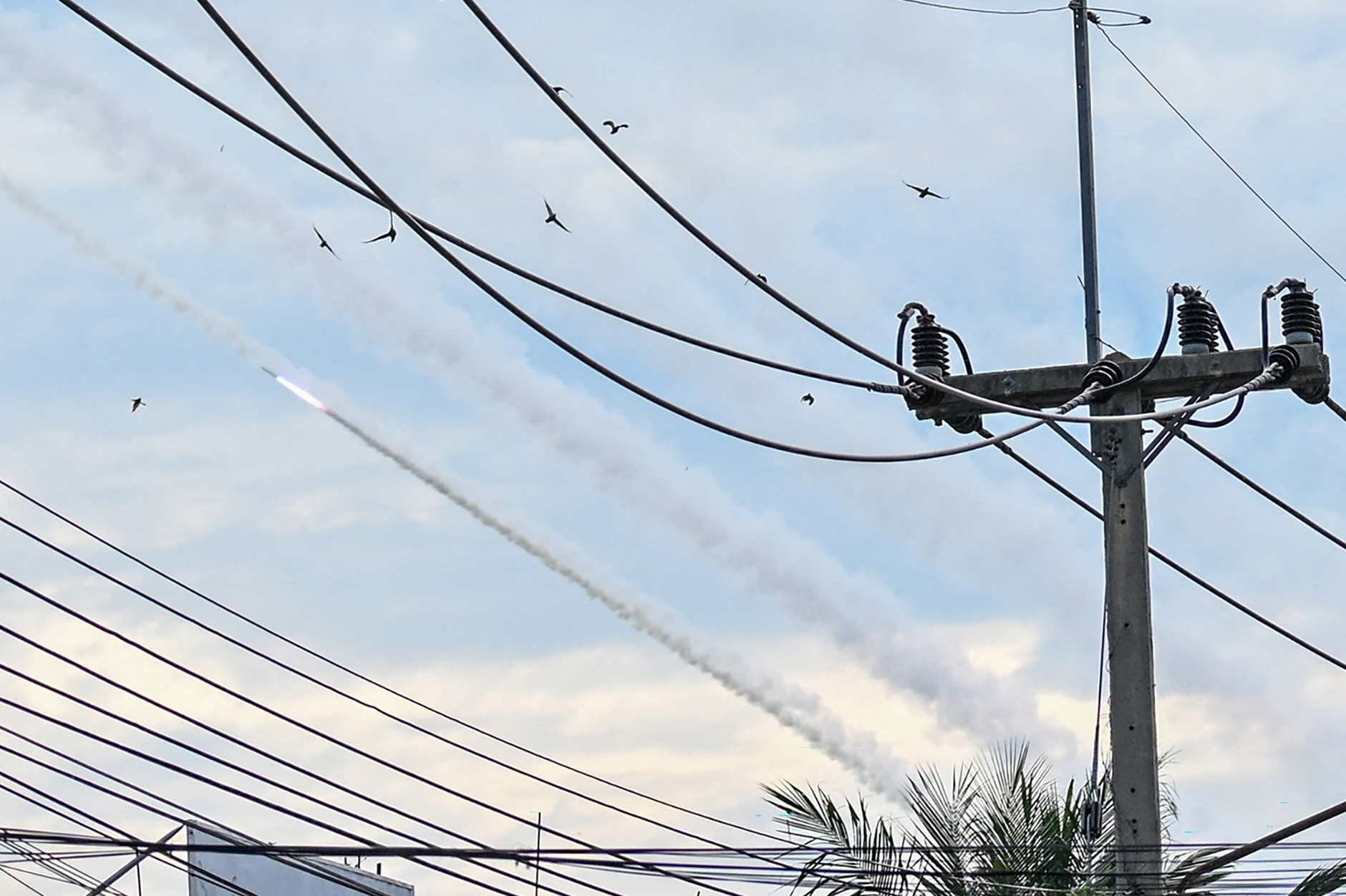 A missile and smoke plumes from a multiple rocket launcher visible in the sky during clashes on the Cambodian-Thai border, Oddar Meanchey province, Cambodia, December 10, 2025.