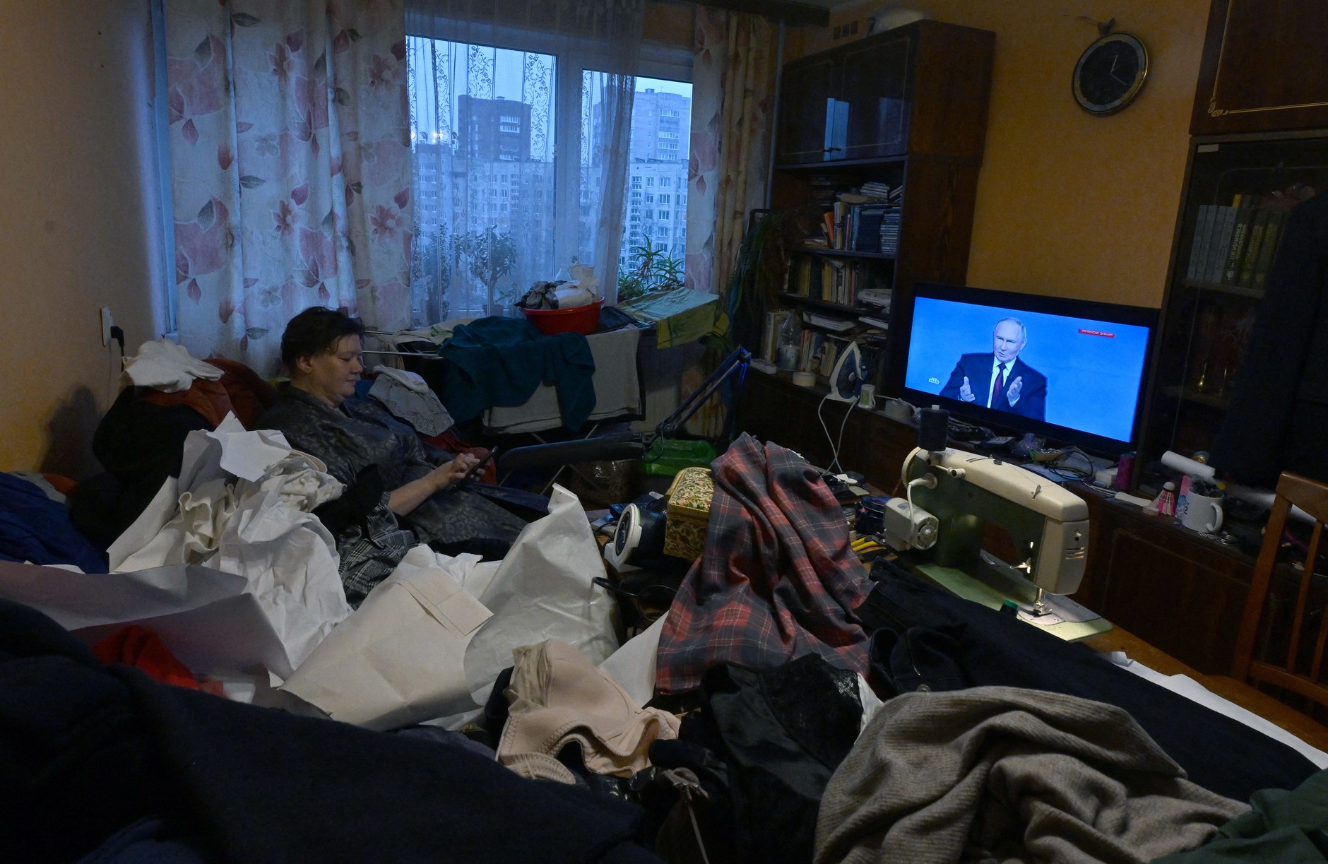 A Russian woman watches the telecast of Vladimir Putin's annual press conference at her apartment in St. Petersburg, Russia, December 19, 2025.