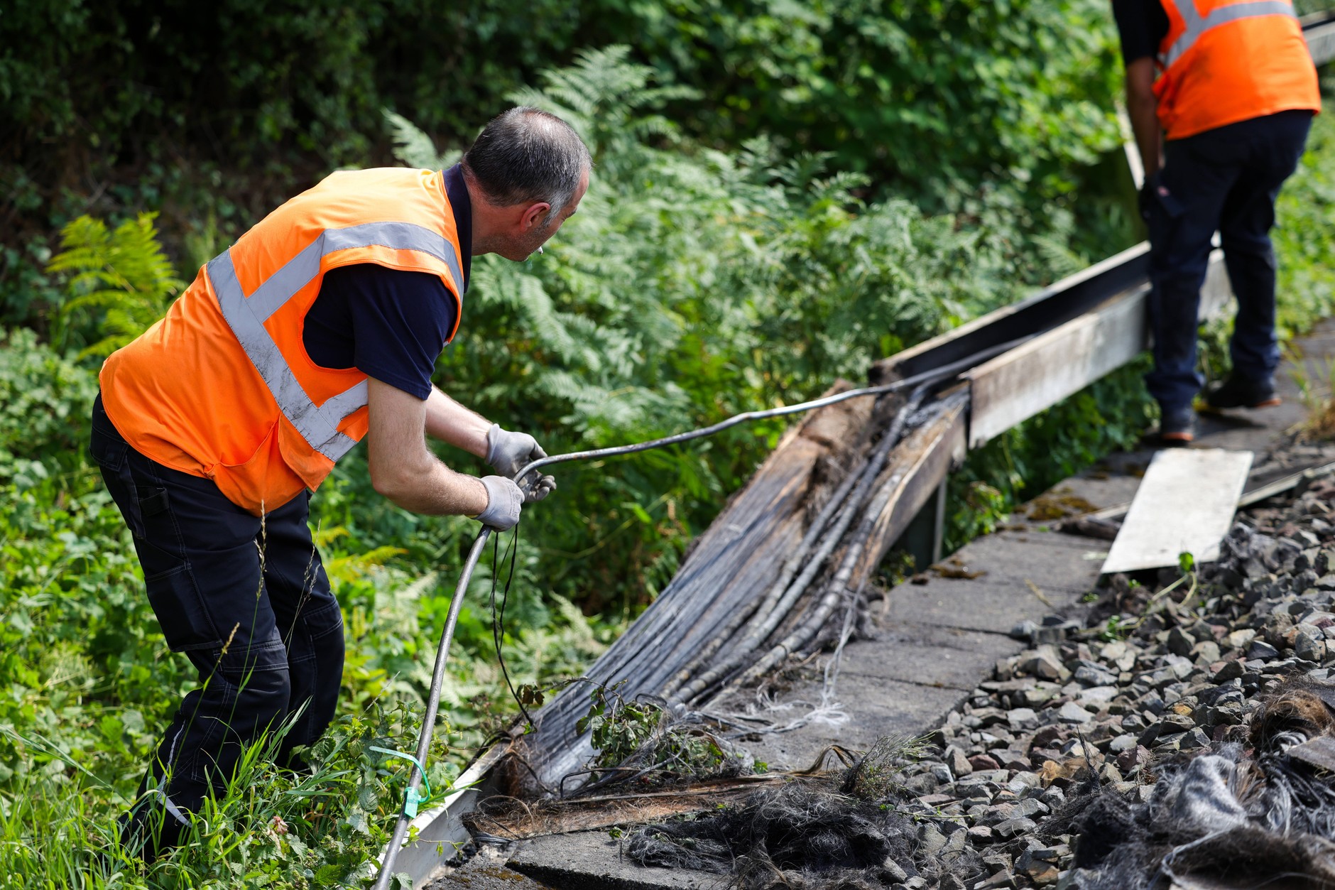 Deutsche Bahn employees inspect a section of tracks after a fire that damaged cables. Duesseldorf, July 31, 2025