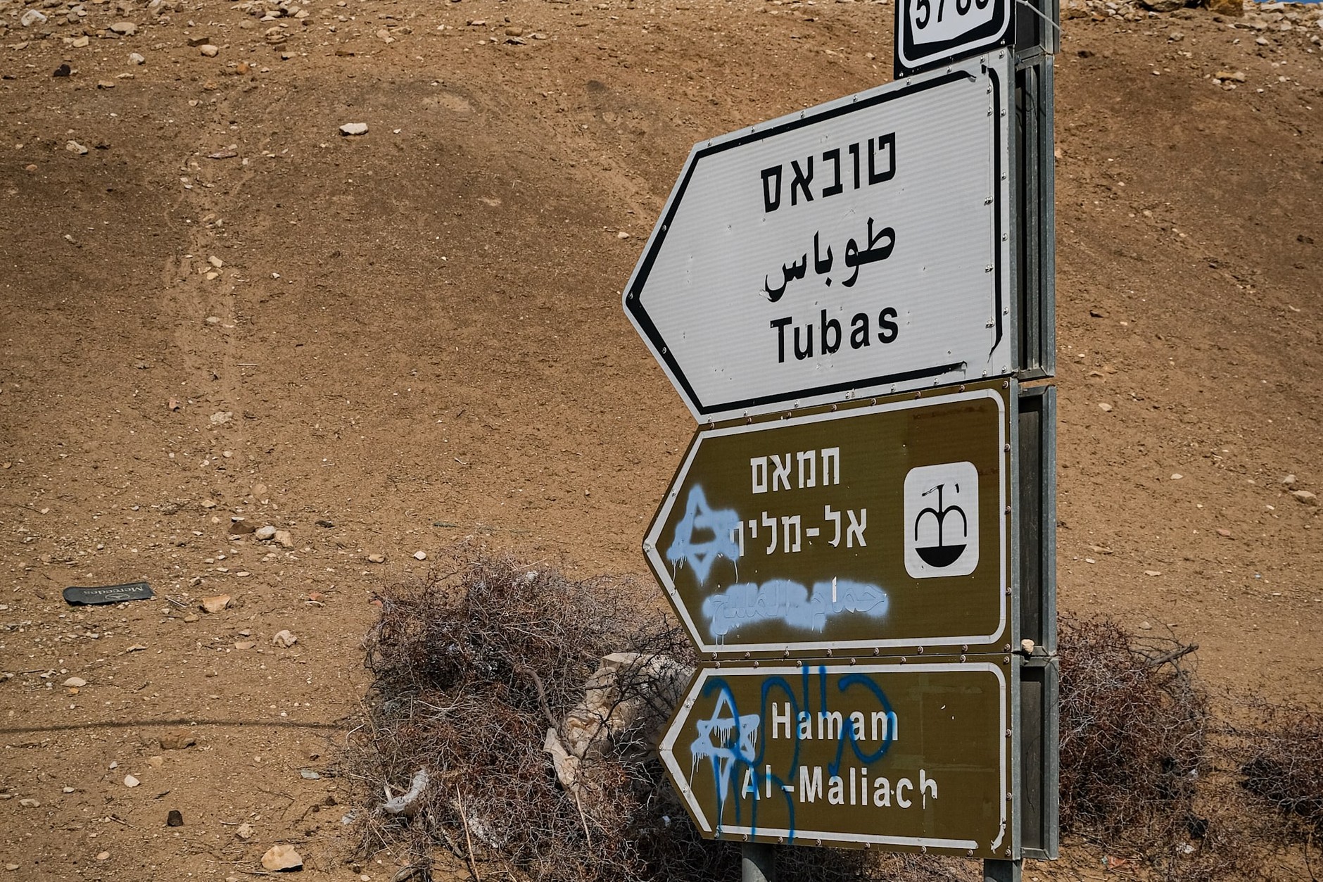 Signs with Arabic place names painted over, most likely by Israeli settlers