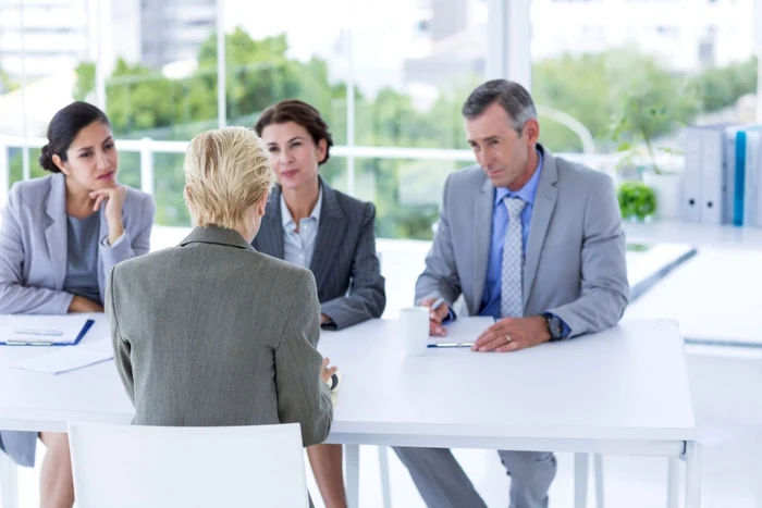 A young woman at an interview with three bosses