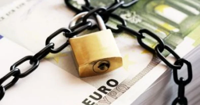 Euro banknotes linked with a chain with a padlock