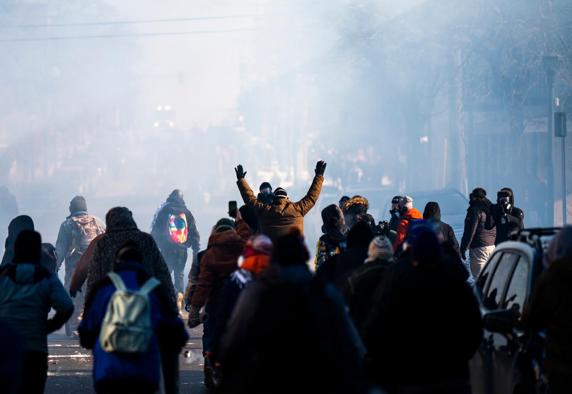 Ludzie maszerują przez chmurę gazu łzawiącego w proteście po śmiertelnym postrzeleniu Amerykanów przez agentów federalnych, Minneapolis, 24 stycznia 2026 r.  