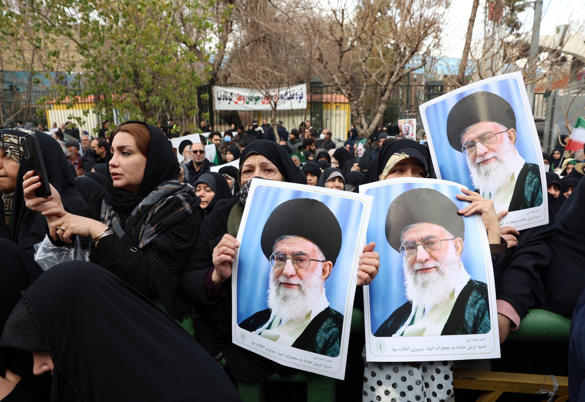 Mourners hold portraits of Ali Khamenei during the funeral ceremony of Iranian security officials. Tehran, January 14, 2026