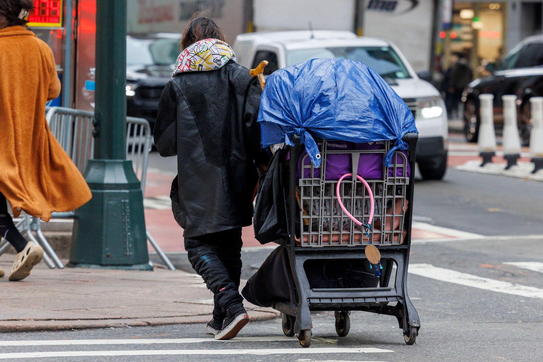 A person in crisis of homelessness transports his belongings in a stroller through the streets of New York, January 29, 2024.