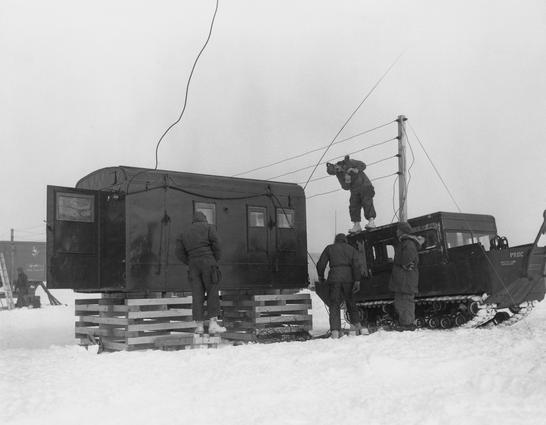 Men from the U.S. Army Polar Research and Development Center setting up communications at a temporary camp used during the construction of Camp Century, Greenland, June 1959.